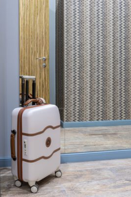 suitcase placed near mirror in room